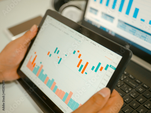 Businessman checking stock market dataมStock Market Application for Mobile, Analyzing Data Stock Market on Mobile Young Businessman with Smartphone and Stock Market Chart Background.