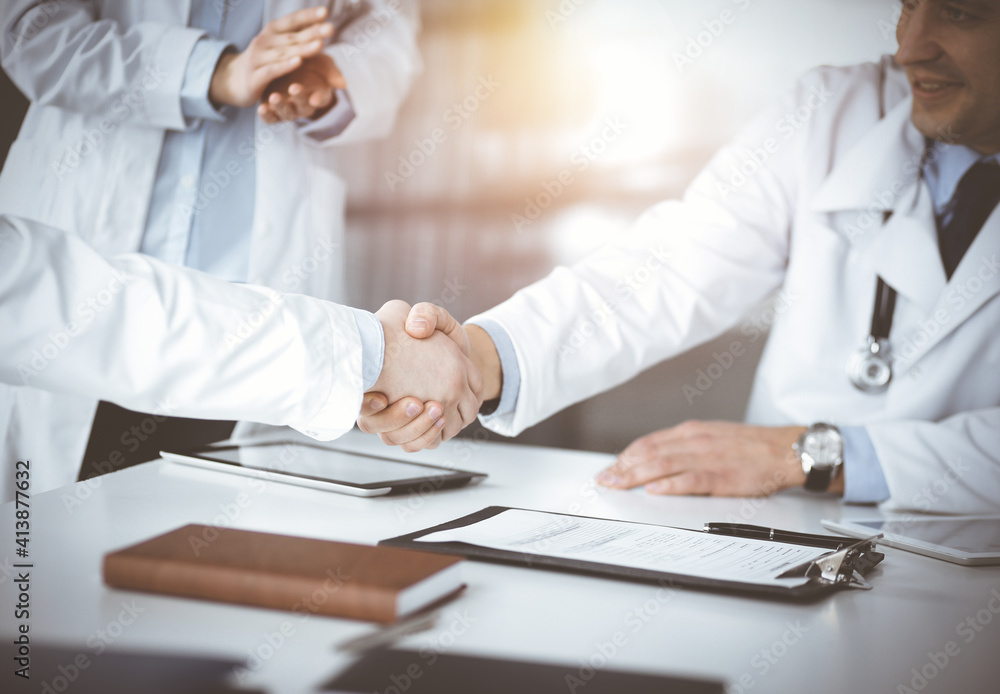 Unknown doctors are shaking their hands as agreement about patient's diagnosis, close-up. Perfect medical help, insurance in health care, medicine concept Unknown doctors are shaking their hands as agreement about patient's diagnosis, close-up. Perfect medical help, insurance in health care, medicine concept