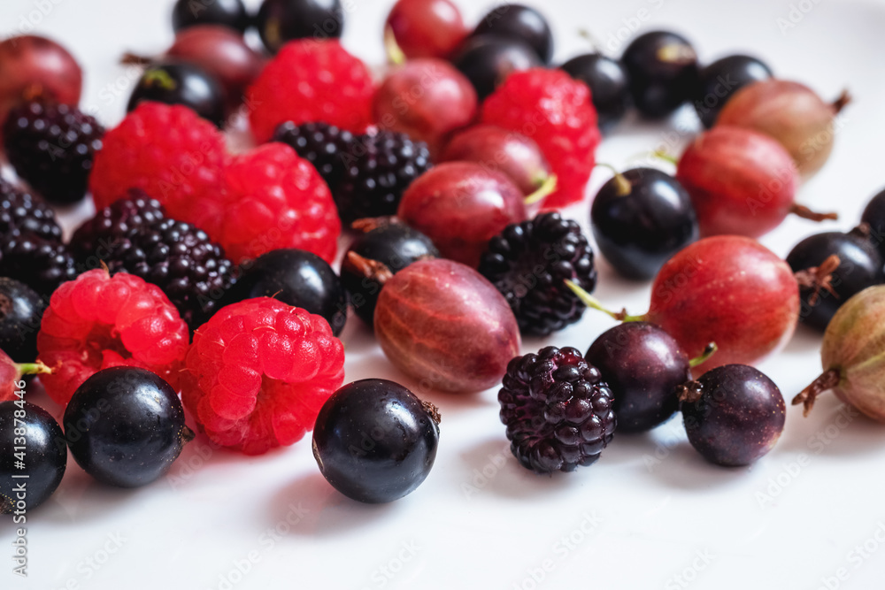 Assorted berries of raspberries, gooseberries, currants on a white background Assorted berries of raspberries, gooseberries, currants on a white background
