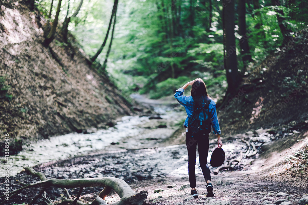 Rear view of young woman exploring forest Rear view of young woman exploring forest