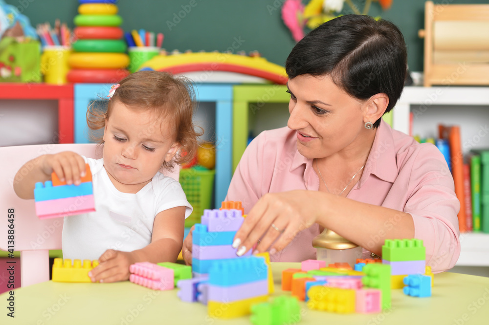 young mother and little daughter playing blocks game young mother and little daughter playing blocks game