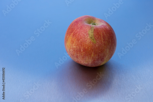 natural ripe minimalist apple and reflection on blue clean metallic background