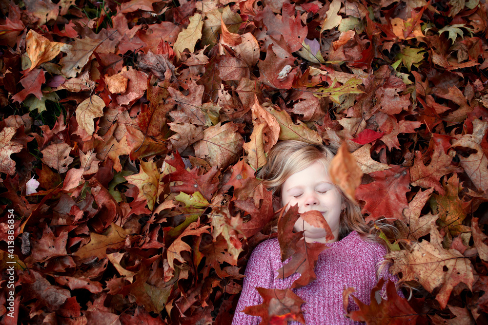 High angle view of girl sleeping on maple leaves High angle view of girl sleeping on maple leaves