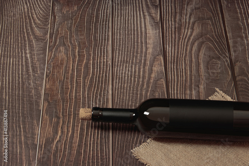  A bottle of wine lies on a background of wooden boards