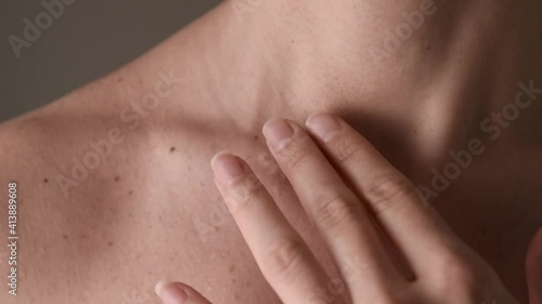 Close up shot of woman touching her surgical scar on collarbone near the neck.