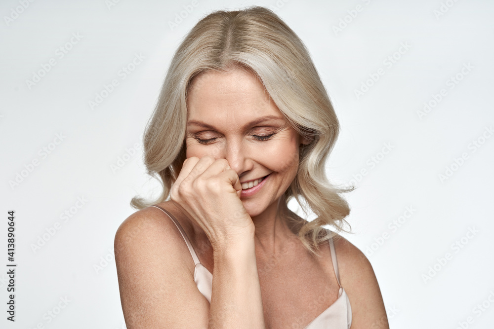 Happy smiling pretty shy 50s middle aged woman laughing, cheerful mature lady touching healthy soft face skin. Anti age healthy skincare treatment and cosmetic ads. Face close up view portrait. Happy smiling pretty shy 50s middle aged woman laughing, cheerful mature lady touching healthy soft face skin. Anti age healthy skincare treatment and cosmetic ads. Face close up view portrait.