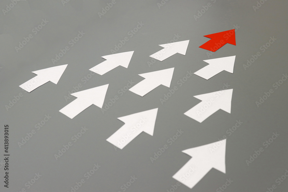 One red paper arrow leading group of white ones. Leadership concept