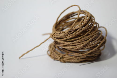 Close-up of a roll of kraft twine on a white background 