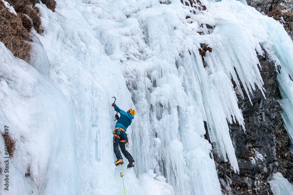 Ice climber on frozen waterfall, Cogne, Aosta Valley, Italy