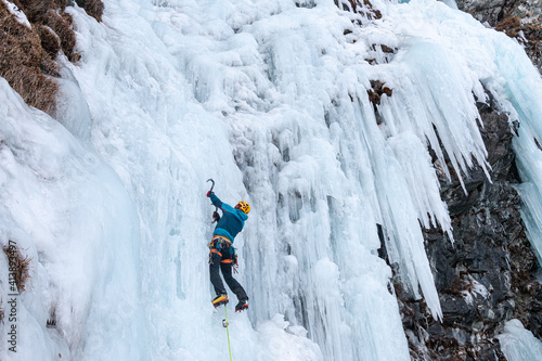 Ice climber on frozen waterfall, Cogne, Aosta Valley, Italy photo
