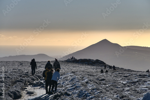 People enjoying hiking and winter Irish weather during coronavirus lockdown, Dublin/Wicklow Mountains, Ireland. Unusual Irish winter. Great Sugar Loaf in the background