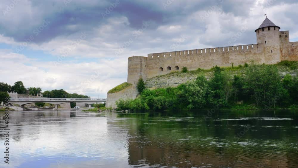 Beautiful cityscape, medieval touristic attraction on Russian Estonian border, Ivangorod fortress on banks of Narva river, cloudy sky horizon Beautiful cityscape, medieval touristic attraction on Russian Estonian border, Ivangorod fortress on banks of Narva river, cloudy sky horizon