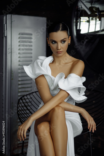 Photo portrait of pretty model sitting on chair wearing white classy dress looking at side