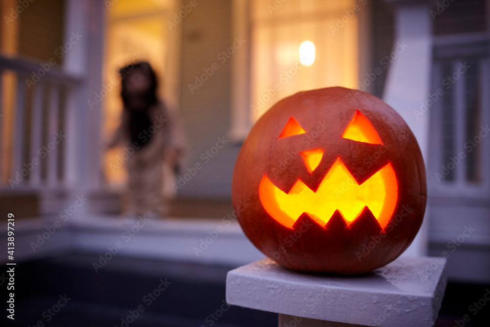 Close-up of jack o lantern with baby boy in background at dusk Close-up of jack o lantern with baby boy in background at dusk