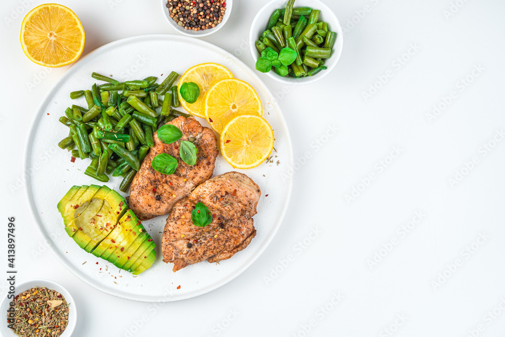 Diet lunch with avocado and poultry meat in a flat plate on a white background. Top view, with space to copy. Diet lunch with avocado and poultry meat in a flat plate on a white background. Top view, with space to copy.