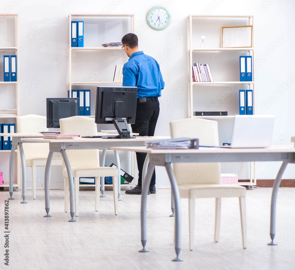 Handsome businessman employee sitting at his desk in office Handsome businessman employee sitting at his desk in office