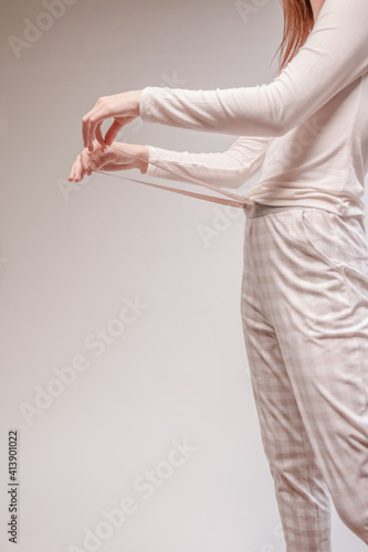 Beautiful sexy woman wearing a beige pajama. Fashion model on a beige background.
