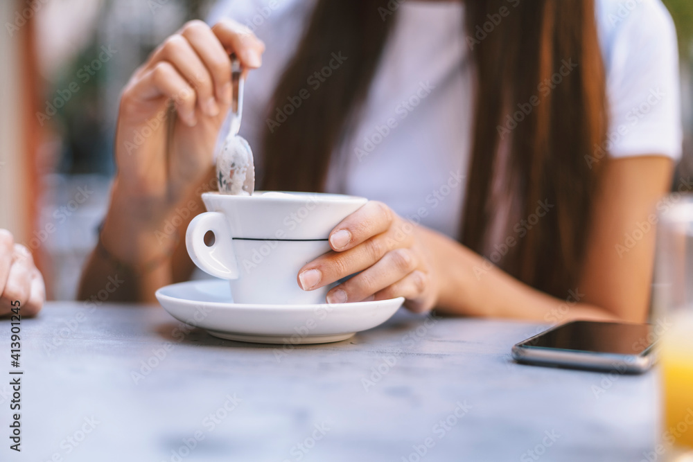 Midsection of woman with cappuccino sitting at sidewalk cafe Midsection of woman with cappuccino sitting at sidewalk cafe