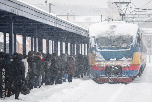 LVIV, UKRAINE - FEBRUARY 10, 2021 : The train arrived at the station, people are waiting, around a lot of snow, Lviv Suburban railway station. photo