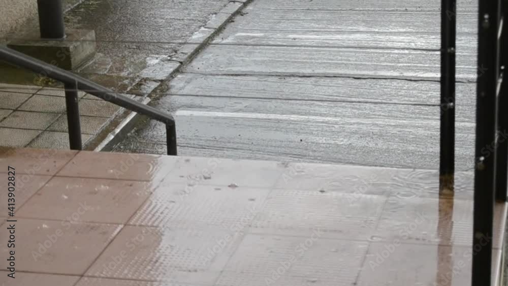 Gotas de lluvia cayendo sobre un charco en las escaleras de la escuela