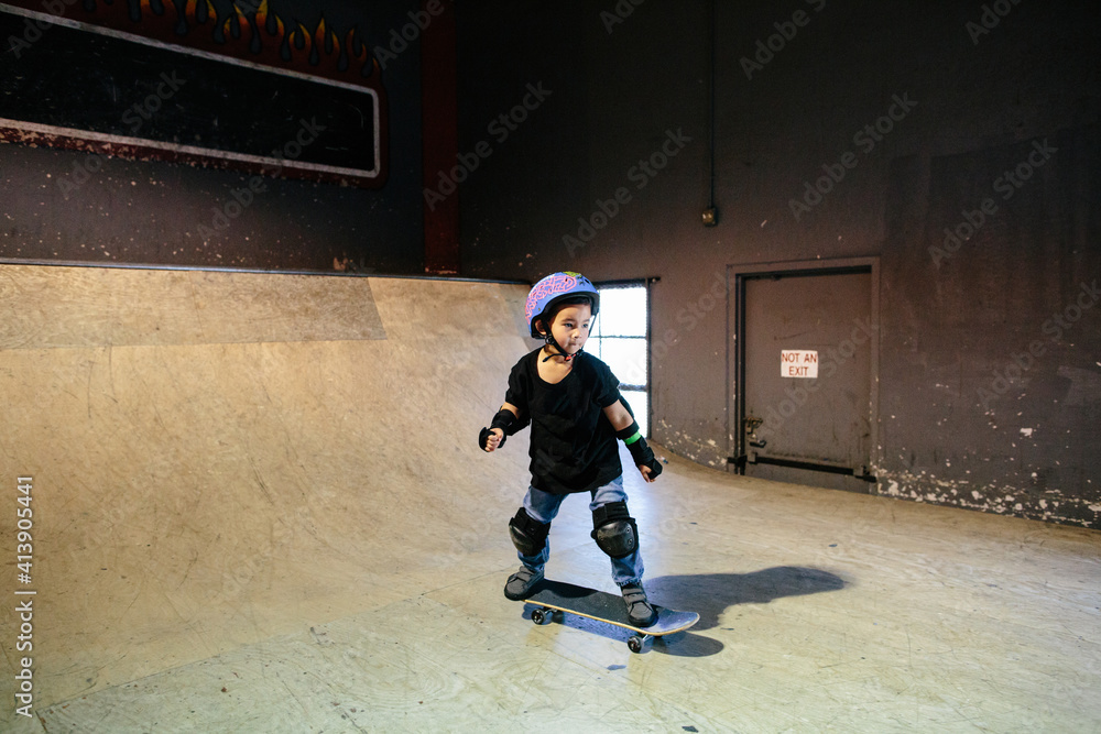 Focused skateboarding boy at an indoor skatepark Focused skateboarding boy at an indoor skatepark