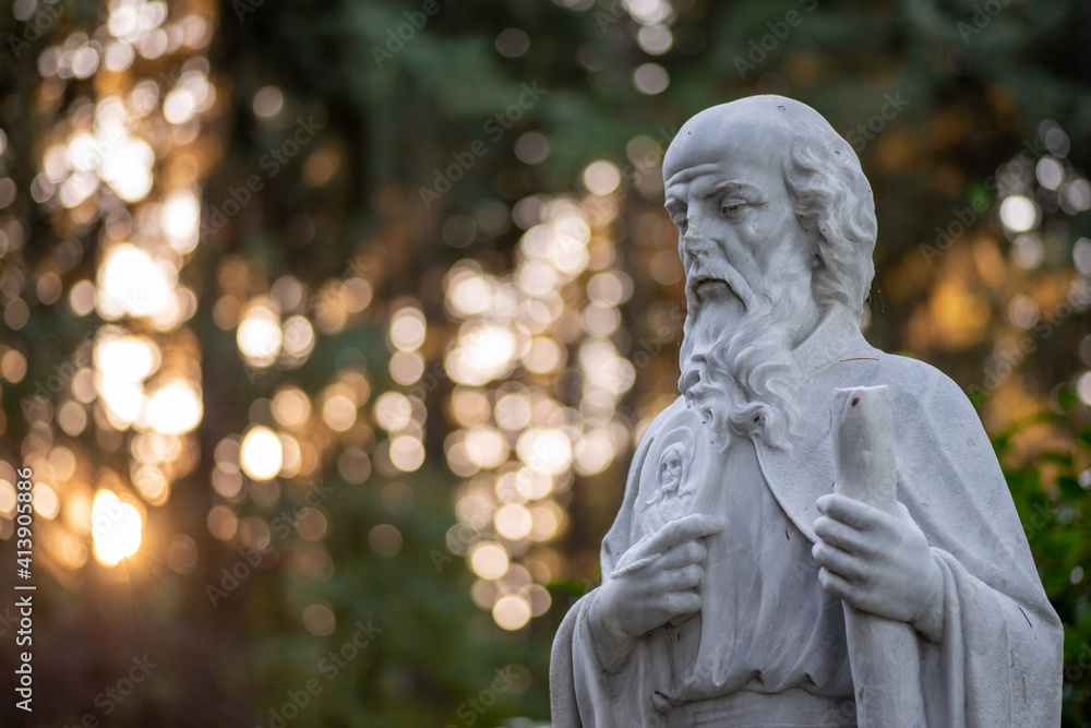 Christian Marble sculpture at sunset with bokeh Christian Marble sculpture at sunset with bokeh