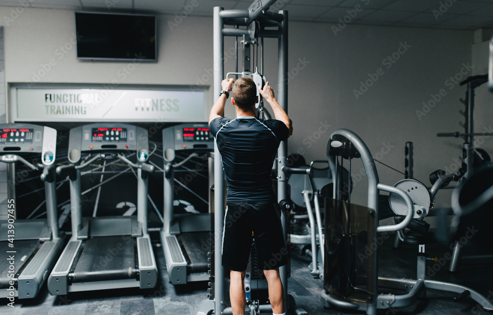 Adjusting the cross machine in the gym. Adjusting the cross machine in the gym.