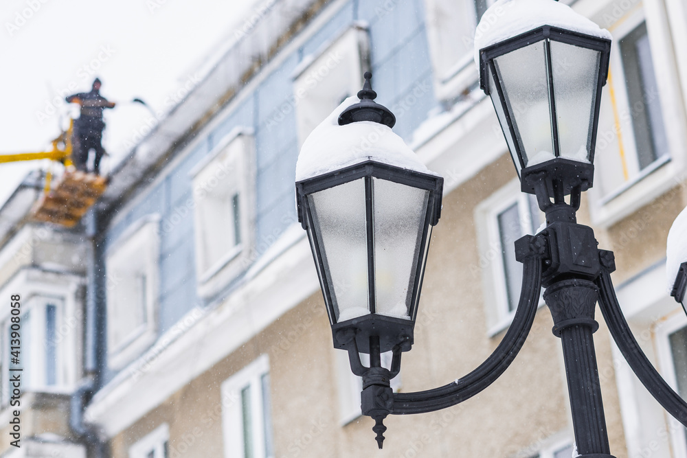 Drohobych, UKRAINE - FEBRUARY 10, 2021: Street lights on city streets, winter time, snow on lantern.