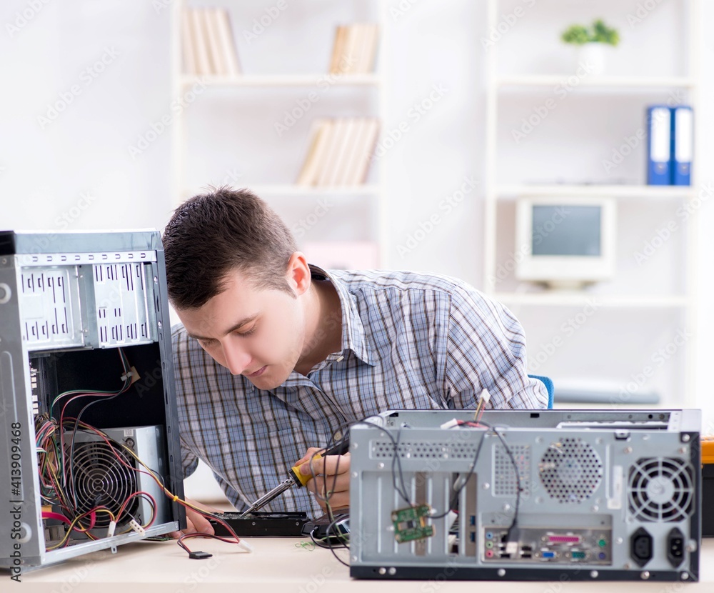 Obraz premium Young technician repairing computer in workshop