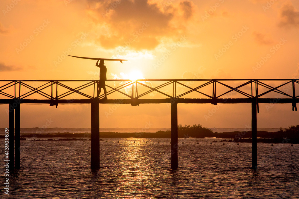 man carrying a surfboard on famous bridge of cloud nine in Philippines man carrying a surfboard on famous bridge of cloud nine in Philippines