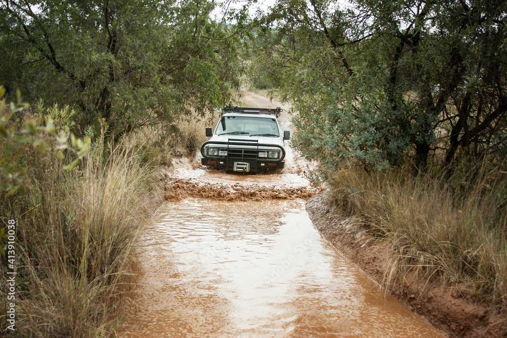 Off-road vehicle in muddy water at forest Off-road vehicle in muddy water at forest