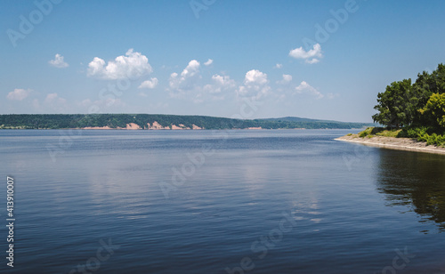 Lake landscape with clouds, wooded shoreline