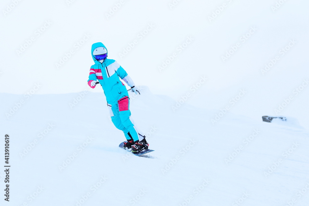 woman snowboarder is snowboarding from the mountain woman snowboarder is snowboarding from the mountain