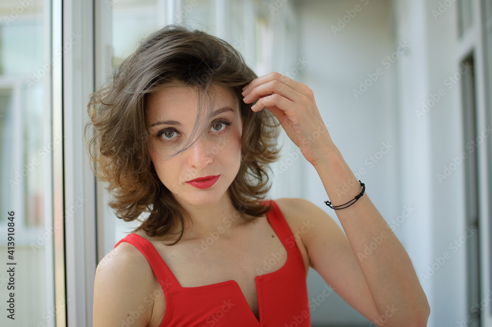Indoor female portrait of young attractive woman in red clothes with sensual lips looking at the camera in studio Indoor female portrait of young attractive woman in red clothes with sensual lips looking at the camera in studio