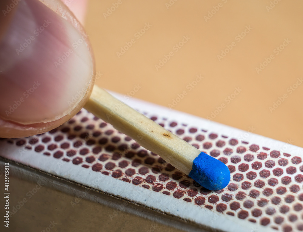 Hand swiping a matchsticks from the striking surface of the matchbox Hand swiping a matchsticks from the striking surface of the matchbox