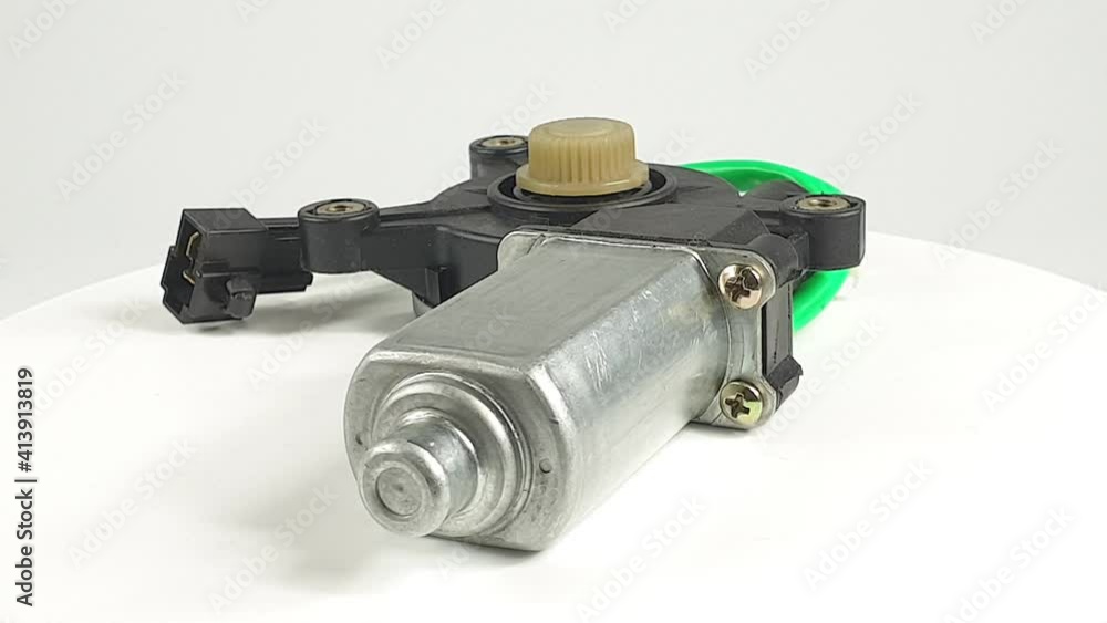 car spare part, electric motor for car window lifters rotates on white background car spare part, electric motor for car window lifters rotates on white background