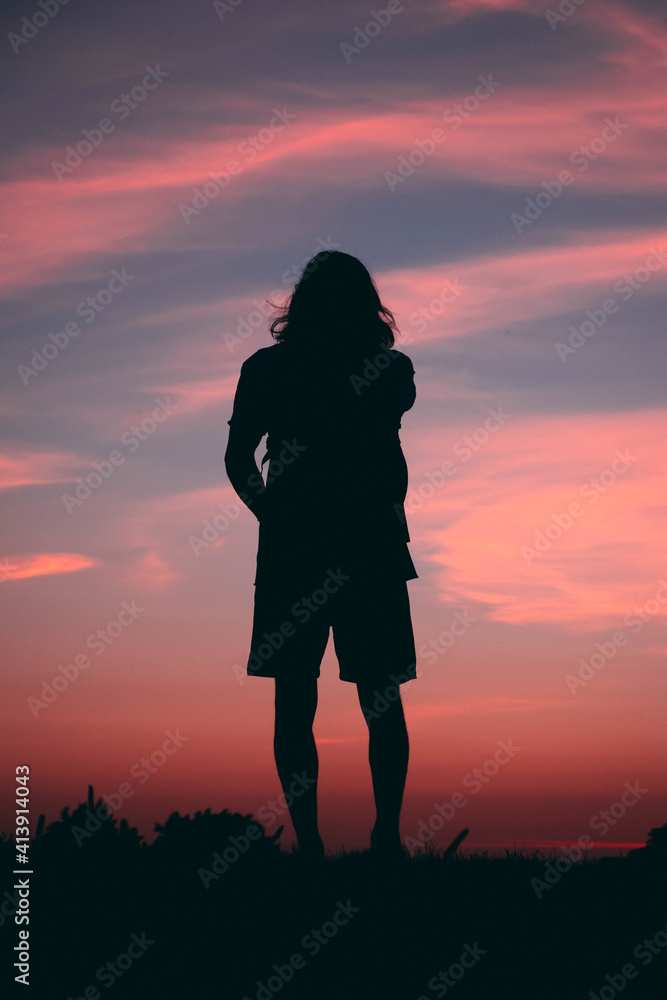 Person at the top of hill watching the sunset Person at the top of hill watching the sunset