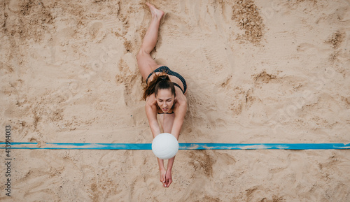 Φωτογραφία Professional player with white ball playing beach volleyball on sand