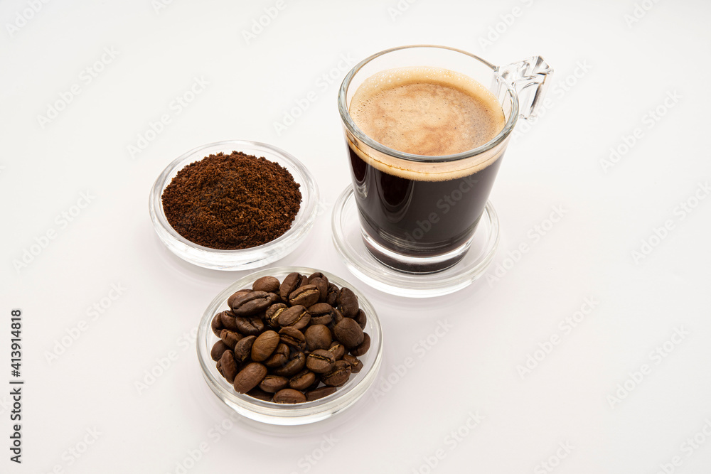 Black coffee in a glass cup and saucer with coffee beans around it
Black coffee in a glass cup and saucer with coffee beans around it