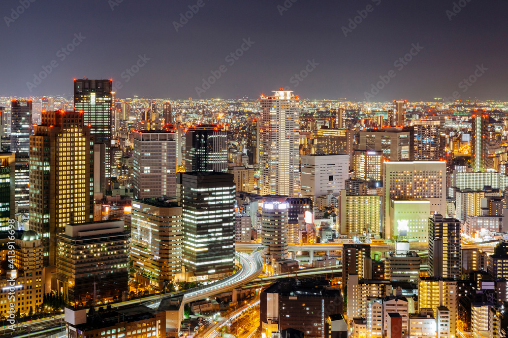 High angle view of illuminated modern buildings against sky at night High angle view of illuminated modern buildings against sky at night