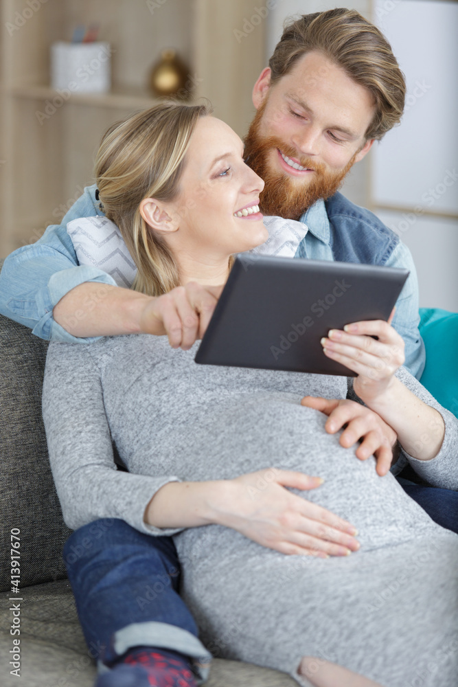 portrait of happy young couple using tablet on sofa portrait of happy young couple using tablet on sofa