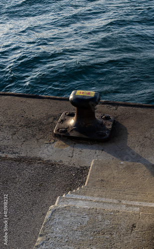 sea bollard in a harbor with a sea in the background