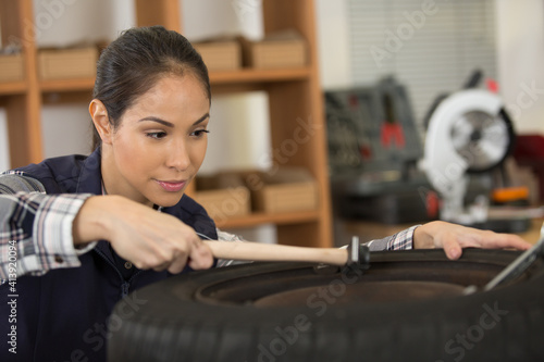 female mechanic going to change car wheel
