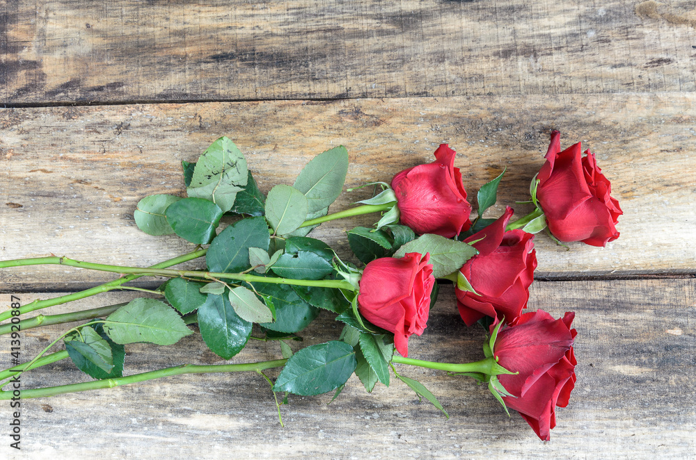Bouquet of red roses over wooden background