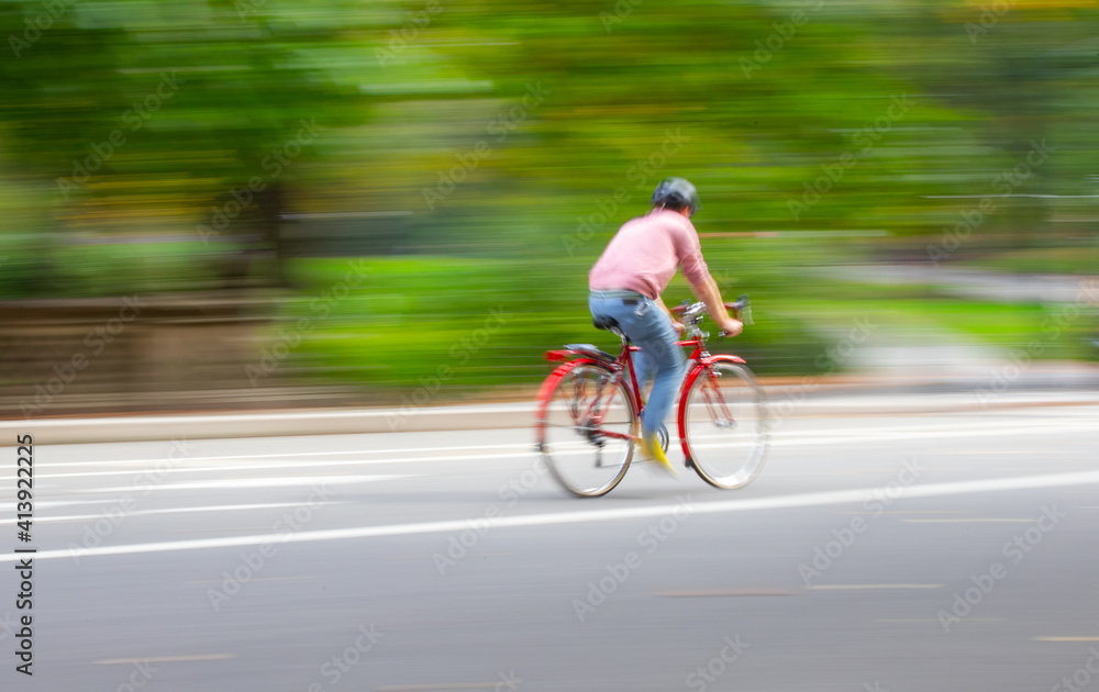 Bike rider moving fast with motion blur wearing pink