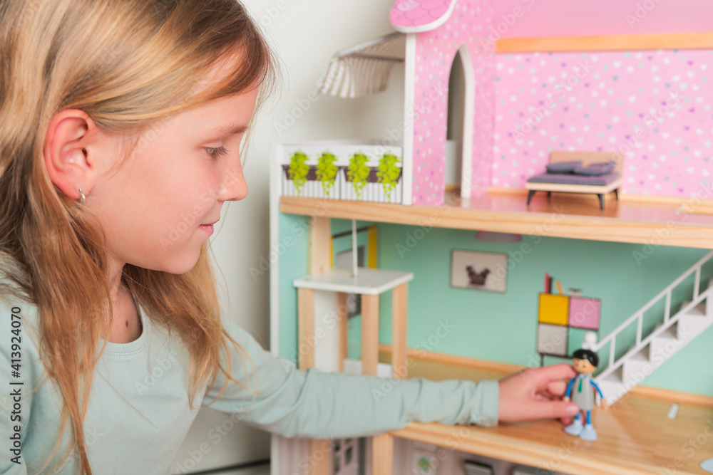 Happy girl plays with doll house and dolls. Happy child. Happy girl plays with doll house and dolls. Happy child.