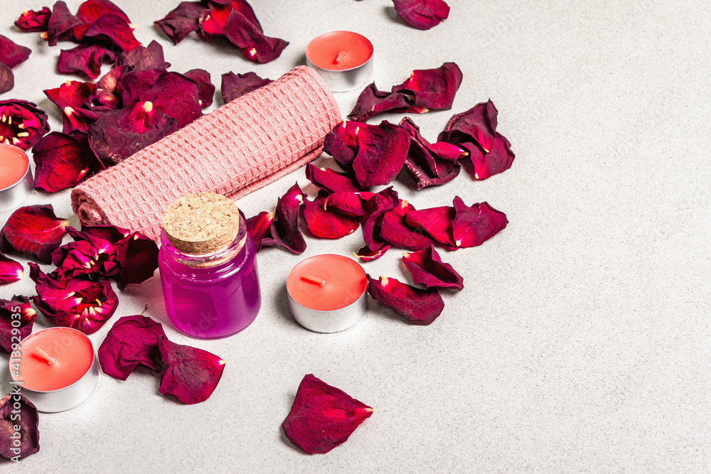 Floral and spa concept with dried roses petals, fragrant candles and soft towel Floral and spa concept with dried roses petals, fragrant candles and soft towel