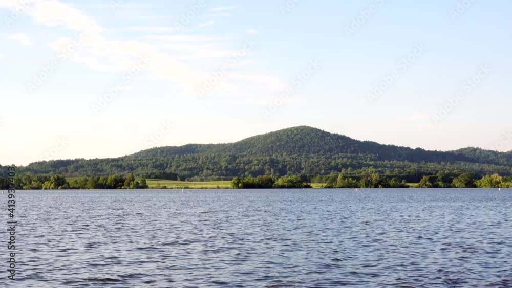 The waters of a lake at the foot of a small hill. The waters of a lake at the foot of a small hill.