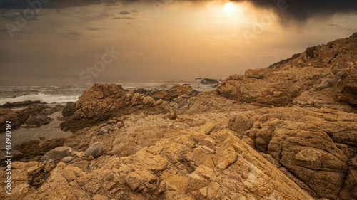 Beautiful seascape, ocean views, rocky coast, sunlight on the horizon. Composition of nature. Sunset scenery background. Cloudy sky. Water Reflection. California Seashore.