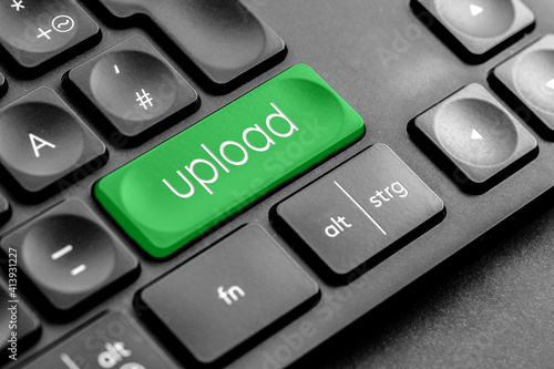 grüne Upload Taste auf einer dunklen Tastatur